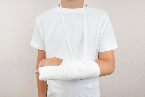 一个戴着石膏的男孩，手臂骨折。裁剪的照片。图片下载