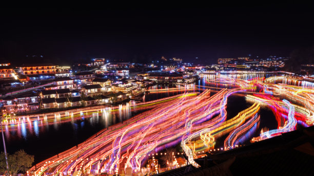 夜晚的班Rak Thai村庄，五光十色的灯光和美丽的装饰灯，湖面上有运动模糊的中国船只，照片叠加概念。图片下载