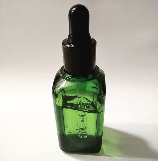 绿色立方体玻璃滴管精华瓶的库存照片图片下载