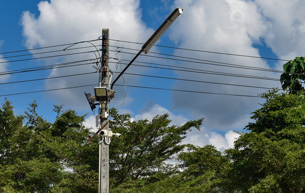 这张照片展示了高耸的电线杆和横跨天空的电缆。图片下载