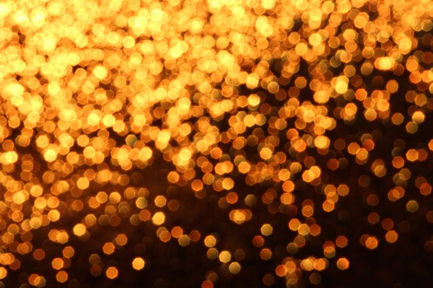 散景效果的照片，模糊的光点形成金色圆圈，背景有纹理。图片下载