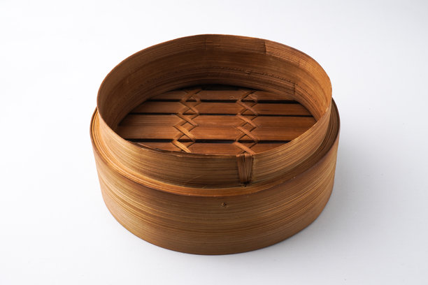 白色背景上孤立的木制点心蒸笼特写照片。以30度平视角度拍摄。图片下载