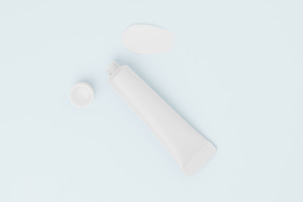 白色空心护肤霜管与蓝色背景上的涂抹。美容产品、面部护肤、眼部保湿、抗衰老的概念。适合您设计的图片。图片下载