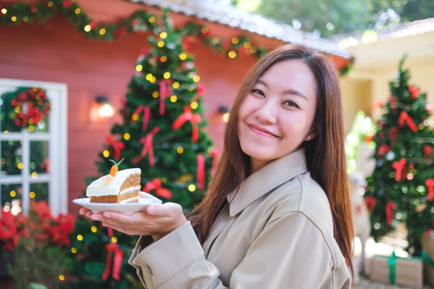 圣诞派对上，一位女性手持胡萝卜蛋糕的肖像照片图片下载