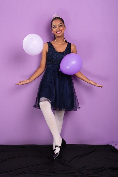 一位棕发少女穿着芭蕾舞服，摆出姿势为照片拍摄。图片下载