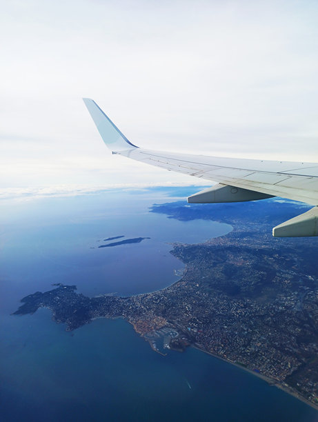 飞机机翼在法国南部地中海上空，能看到戛纳、勒林群岛和安提布的照片图片下载