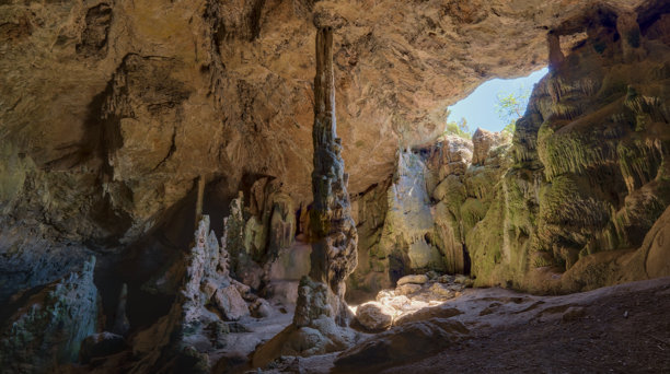 这张图片展示了一个自然洞穴的内部，里面有高耸的钟乳石。图片下载