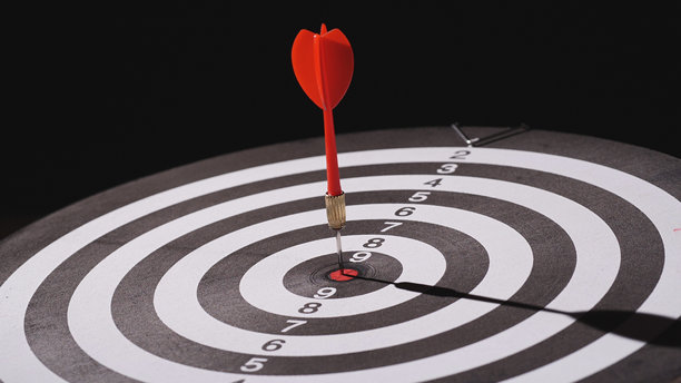 目标、商业、目标、瞄准、成功、战略、专注的概念。黑色背景下的红色飞镖箭头在靶心目标或飞镖盘上。目标、目标市场、目标的概念。图片下载