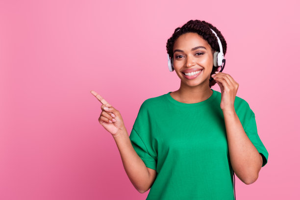 时尚穿着绿色衣服的迷人年轻女性在粉色背景前的空白空间中拍摄的肖像照片图片下载