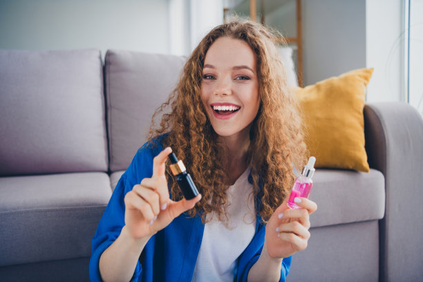 可爱的女孩美容博主在室内平坦的地方宣传销售化妆品精华液的照片图片下载