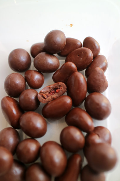 黑色塑料容器中的深棕色巧克力颗粒照片图片下载