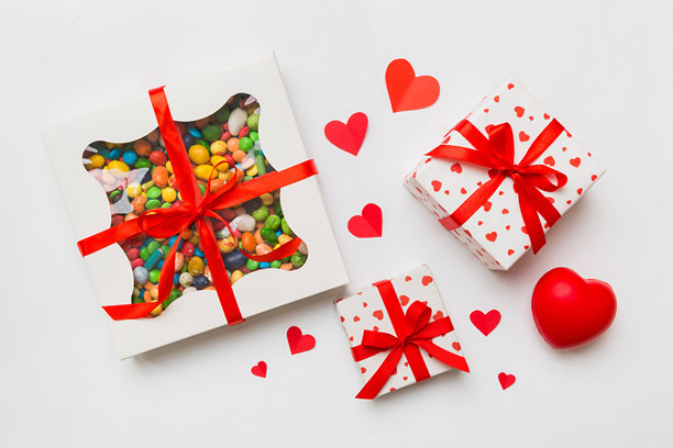情人节构图：甜蜜的糖果，带有蝴蝶结的礼品盒和红色毛毡心形，照片模板，背景。俯视图，留白空间。图片下载