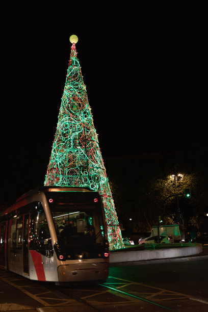 西班牙阿拉贡萨拉戈萨的圣诞树。夜景照片。圣诞灯饰。电车经过。图片下载