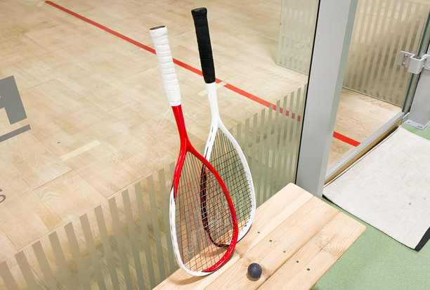 两把球拍和两个壁球在镶木地板上。横向照片图片下载