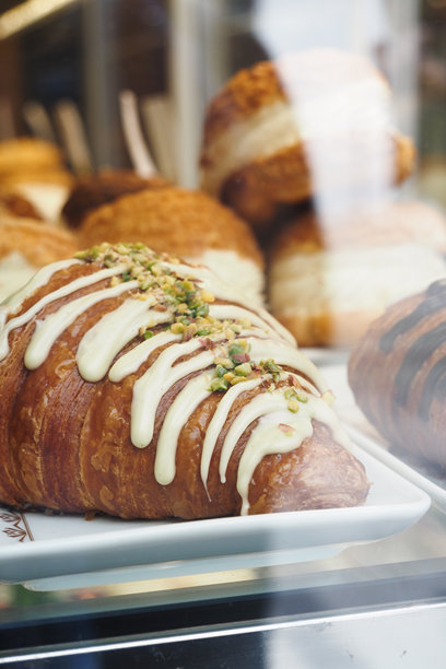 商店里透明玻璃容器中的新鲜烘焙可颂面包的竖拍照片图片下载