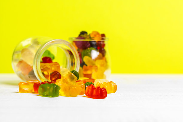 桌子上摆放着装有甜蜜糖果的瓶子。创意照片。图片下载