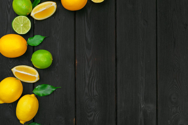 木质背景上的柠檬和青柠。创意照片。图片下载
