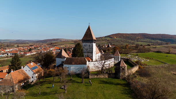 一张令人惊叹的无人机照片，展示了罗马尼亚霍斯曼堡垒教堂的宏伟与历史之美，捕捉了这座中世纪建筑的壮丽。图片下载