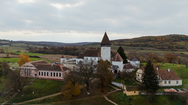 一张令人惊叹的无人机照片，展示了罗马尼亚霍斯曼堡垒教堂的宏伟与历史之美，捕捉了这座中世纪建筑的壮丽。图片下载