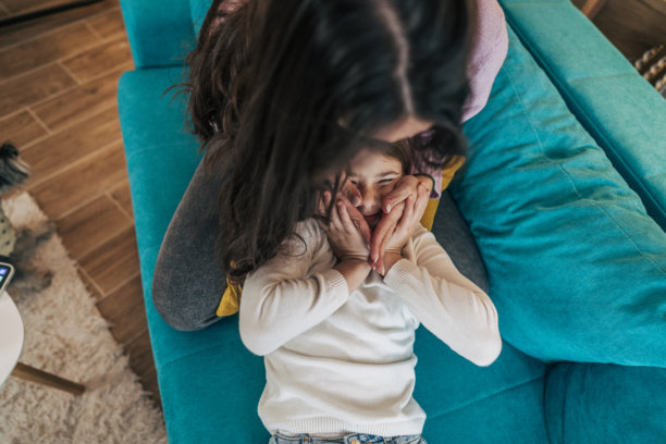 这张图片是从上方拍摄的，捕捉了一个温馨、亲密的时刻，场景是在一个舒适的客厅里。图片下载