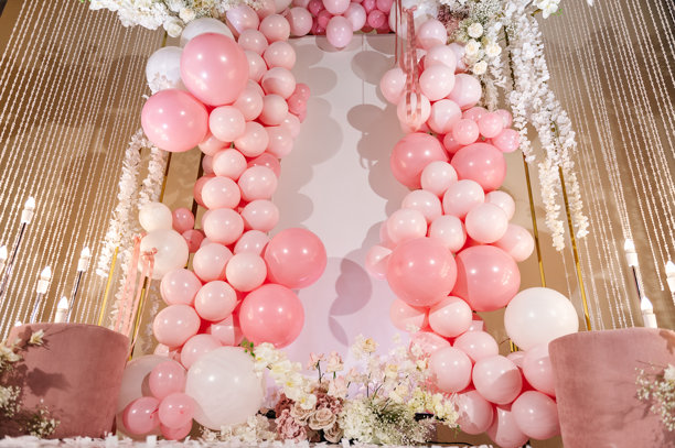 装饰有粉色和白色气球、蜡烛、花朵的拱门。照片墙装饰空间或文本区域。婚礼接待的拍照区，或庆祝女孩生日派对的节日区域。图片下载