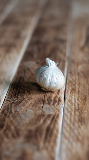 一头大蒜放在木板背景上，垂直照片，浅景深，极简主义，留白空间图片下载