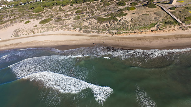 直升机俯瞰西班牙卡拉霍达镇美丽海滩的照片，展示了卡博皮诺海滩和沙丘，阳光明媚。图片下载