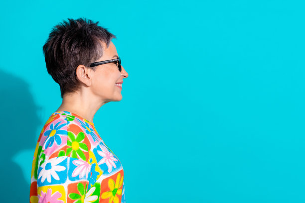 穿着T恤的和蔼老年女性在青绿色背景前凝视空旷的空间的个人头像照片图片下载