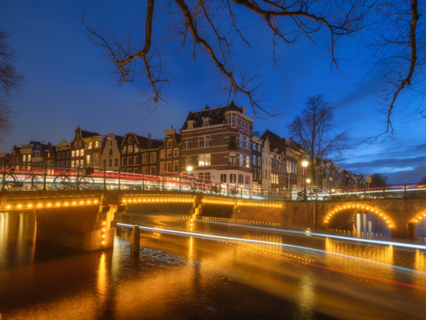 阿姆斯特丹，荷兰。傍晚的城市风景。黑暗的天空和城市灯光。荷兰运河。水面上的倒影。适合用作背景、壁纸和明信片的照片。图片下载