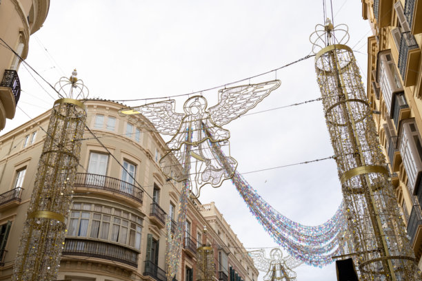 西班牙马拉加市中心的照片，展示了主街道上节日的圣诞灯饰，十二月份的天使形状的灯光已关闭。图片下载