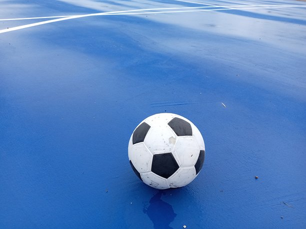 五人制足球在蓝色的五人制足球场表面，特写照片图片下载