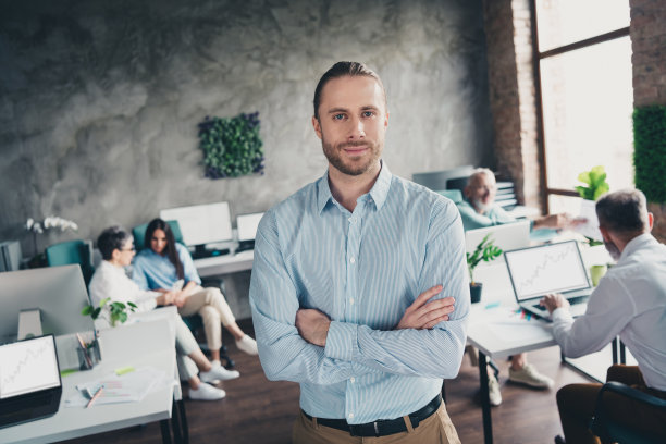 年轻自信的老板在现代办公室阁楼内舒适的工作空间中，双手交叉与团队成员一起合作的照片图片下载