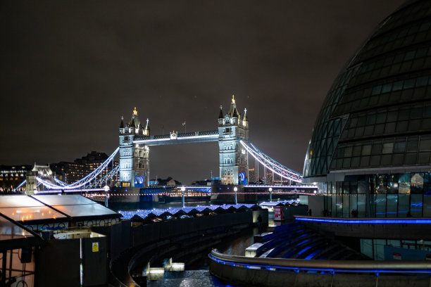 伦敦塔桥夜景倒映在泰晤士河中。库存照片图片下载
