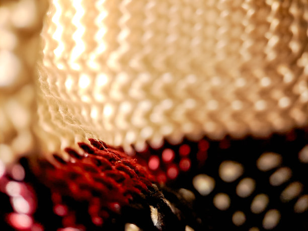 钩织面料，白色、酒红色和黑色纱线交织出迷人的效果。这张照片突显了复杂的纹理。图片下载