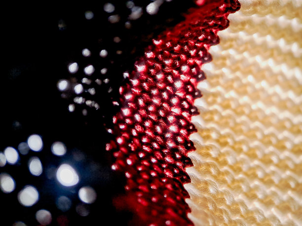 钩织面料，白色、酒红色和黑色纱线交织出迷人的效果。这张照片突显了复杂的纹理。图片下载