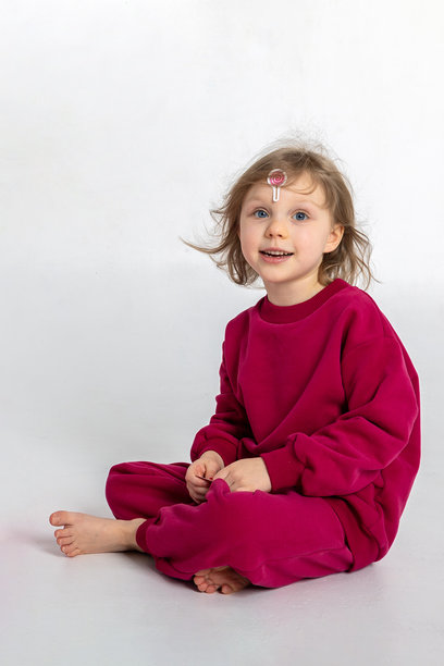 快乐玩耍的小女孩肖像。孩子在明亮的背景下露出微笑和有趣的表情。竖版照片图片下载