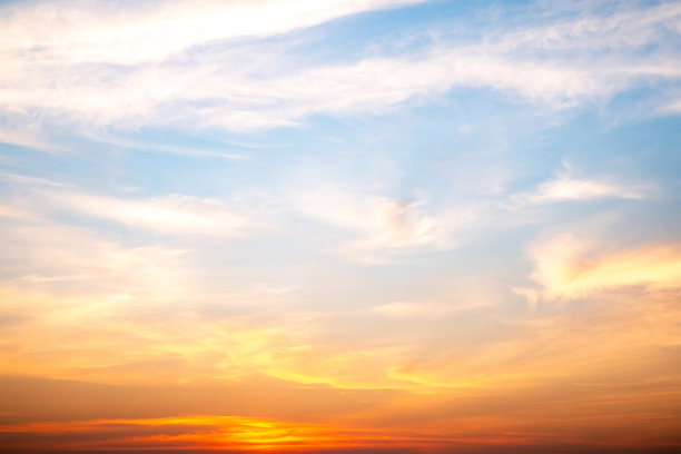 美丽奢华的柔和渐变橙金色云彩和阳光映衬在蓝天上，完美适合作为背景，拍摄于黄昏时分，清晨，超大尺寸，高分辨率的风景照片图片下载