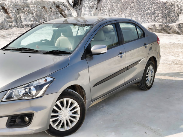 在雪覆盖的山丘上拍摄的马鲁蒂铃木Ciaz汽车图片图片下载