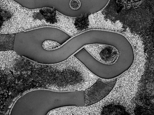 黑白航拍的卡丁车赛道照片。赛道有曲折的转弯和斜纹的沥青边缘，以提供更好的赛车体验。适合儿童。单色，灌木，乐趣，笑话，有趣，花园图片下载