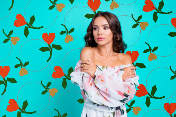 侧面肖像照片，展现出迷人、惊艳、可爱、好看的棕发女性，侧头抱住自己，背景为鲜艳的青色，留有文本空白。图片下载