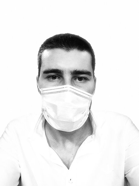 年轻男子佩戴医用口罩的肖像，黑白戏剧性照片，白色背景图片下载