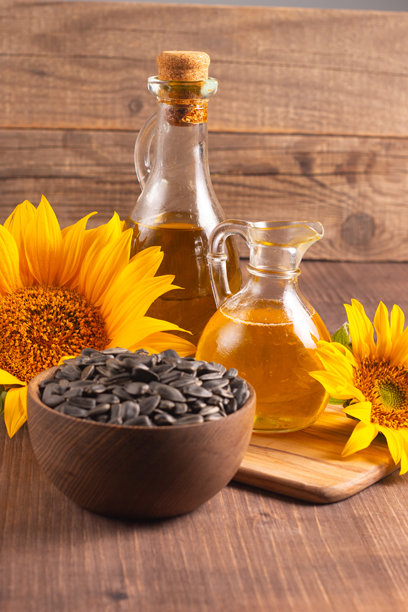 向日葵油特写照片，背景为木质桌面，旁边有种子。生物和有机产品概念。图片下载
