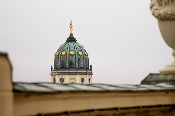 新德国大教堂圆顶特写。标志性的柏林地标，金色雕像细节，从法国教堂的屋顶露台俯瞰，背景是柔和的天际线。极简主义照片。留白空间。图片下载