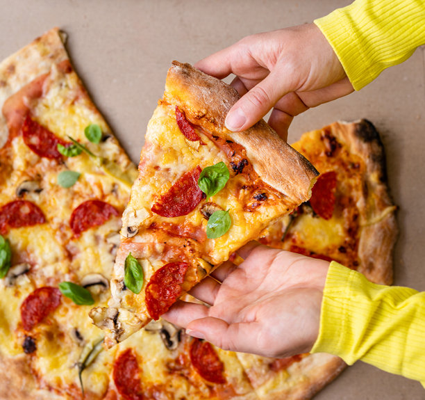 女性手中拿着一片披萨的俯视照片图片下载