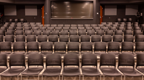 新学校剧院的照片，礼堂，大型教学空间，配有灰色座椅和椅子。图片下载