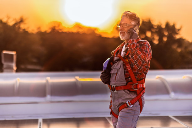 技术人员检查安装在建筑屋顶的太阳能发电厂的库存照片图片下载