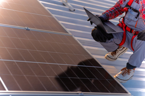 技术人员检查安装在建筑屋顶的太阳能发电厂的库存照片图片下载