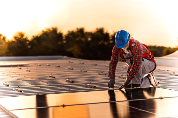 技术人员检查安装在建筑屋顶的太阳能发电厂的库存照片图片下载