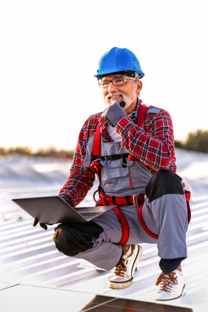技术人员检查安装在建筑屋顶的太阳能发电厂的库存照片图片下载