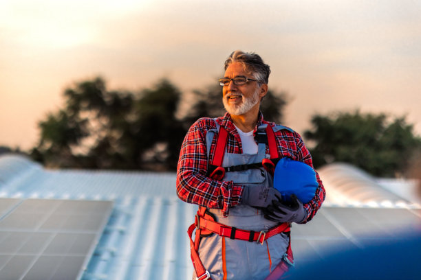 技术人员检查安装在建筑屋顶的太阳能发电厂的库存照片图片下载